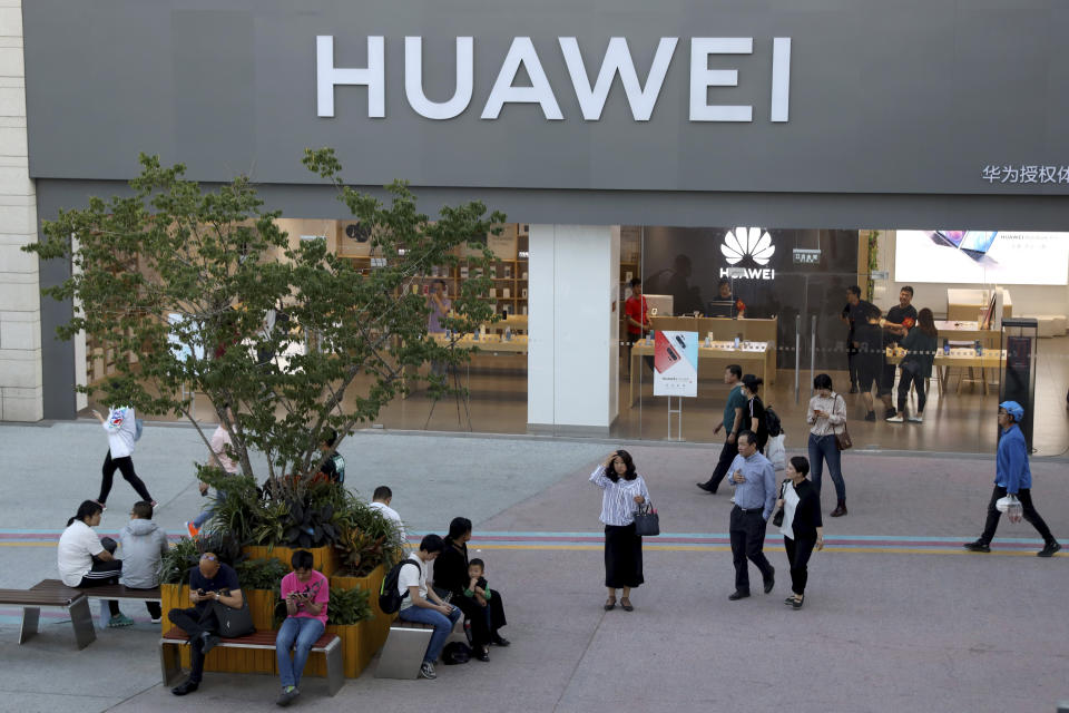 A woman gets her bearing outside a Huawei store in Beijing Monday, May 20, 2019. Google is assuring users of Huawei smartphones the American company's services still will work on them following U.S. government restrictions on doing business with the Chinese tech giant. (AP Photo/Ng Han Guan)