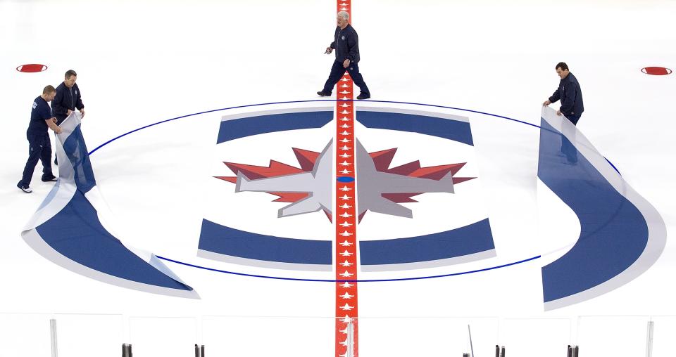 WINNIPEG, CANADA - JANUARY 8: Ice technicians install the Winnipeg Jets logo at centre ice at the MTS Centre on January 8, 2013 in Winnipeg, Manitoba, Canada. (Photo by Marianne Helm/Getty Images)