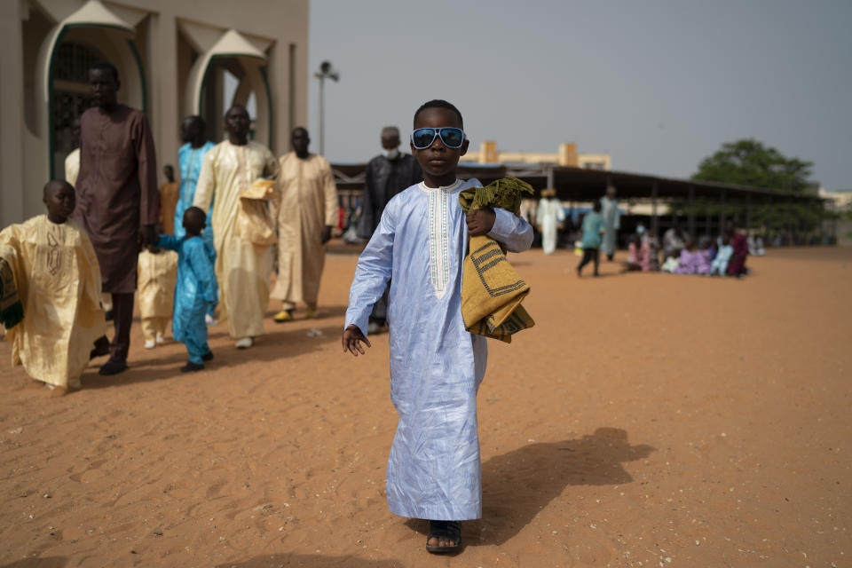 A Senegalese youth walks away from the Mosque after attending the Eid al-Adha prayer in Dakar, Senegal, Wednesday, July 21, 2021. People attend Tabaski celebrations as COVID-19 cases surge in the West African nation. (AP Photo/Leo Correa)