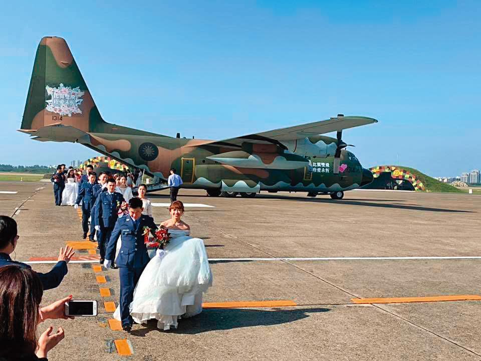 新竹空軍基地3年前舉辦集團結婚，70對新人乘軍用運輸機滑行至機棚婚禮會場，時任空軍司令張哲平帶妻子一同證婚。（翻攝空軍司令部臉書）