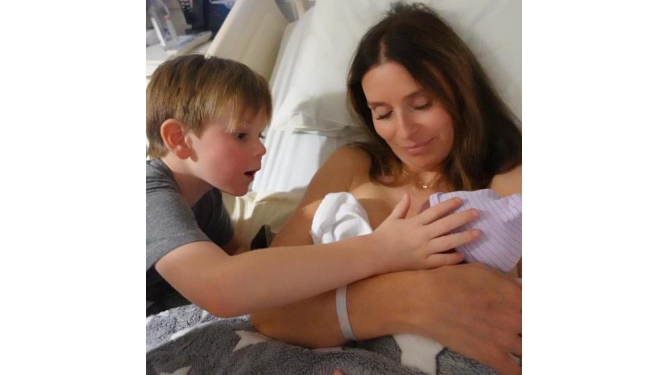 Tana Ramsay holding baby son Jesse while son Oscar watches over them