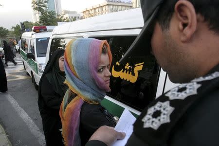 Morality police take down the name of a detained woman during a crackdown on "social corruption" in north Tehran in this June 18, 2008 file photo. REUTERS/Stringer/Files