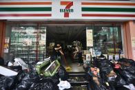 <p>Workers clear water and damaged goods from a convenience store in Macau on Aug. 24, 2017. (Photo: Anthony Wallace/AFP/Getty Images) </p>