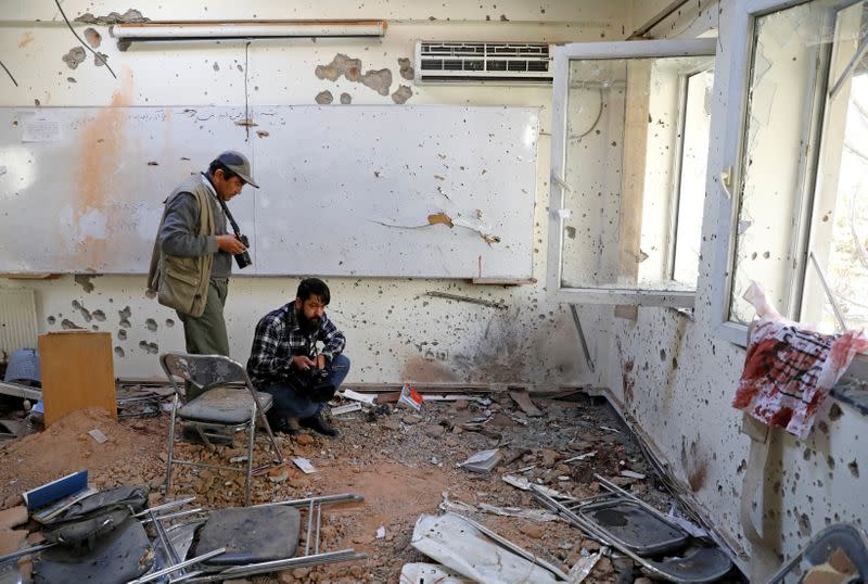 FILE PHOTO: Afghan journalists film inside a class after yesterday's attack at the university of Kabul