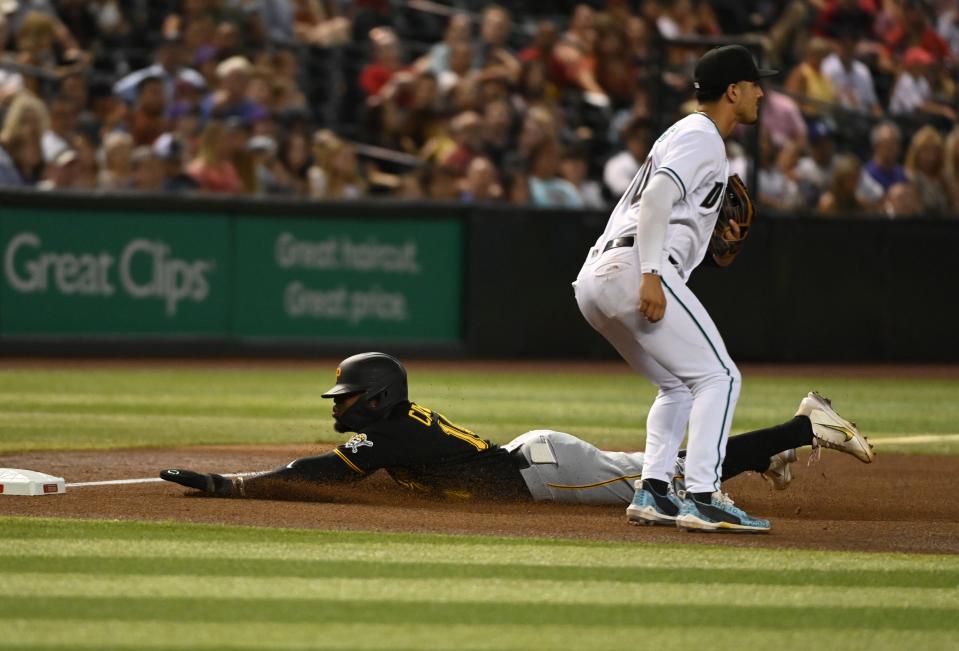 Pittsburgh Pirates infielder Rodolfo Castro's phone begins to slide out of his pocket as he slides into third base.