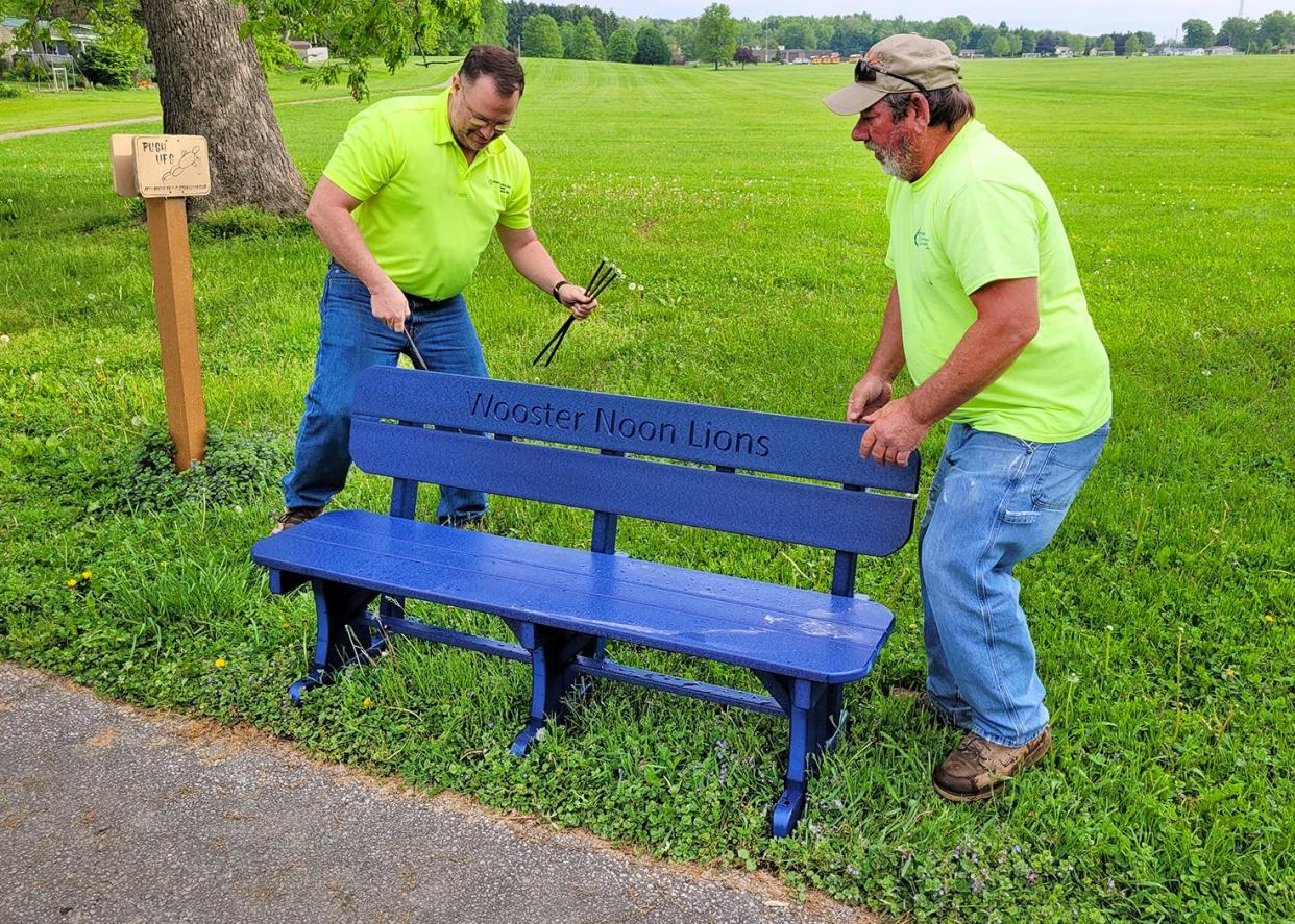 Tim Bogner, left, and Brian Staley of Bogner Construction install an environmentally friendly bench at Kinney Field made from 500 pounds of plastic bags.