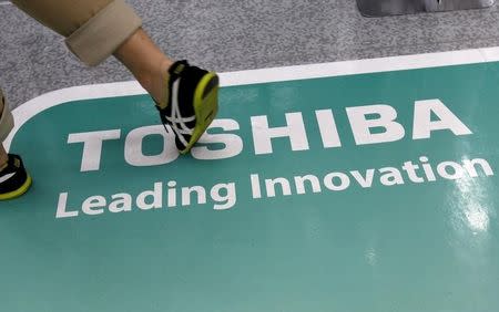 A man walks on a Toshiba advertisement at an electronics shop in Tokyo September 30, 2015. REUTERS/Toru Hanai