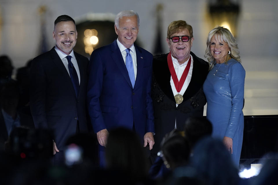 David Furnish, husband of Elton John, left, Elton John, President Joe Biden and first lady Jill Biden pose for a photo after Biden presented Elton John with a National Humanities Medal after a concert on the South Lawn of the White House in Washington, Friday, Sept. 23, 2022. (AP Photo/Susan Walsh)