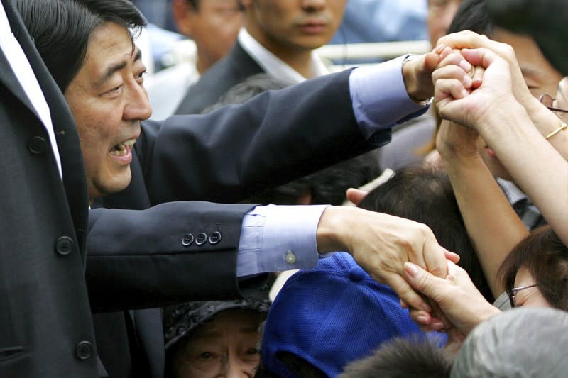 2022年7月8日，日本前首相安倍晉三遇刺身亡。圖為2006年9月16日，時任內閣官房長官的安倍晉三在新宿與支持者握手。（美聯社）