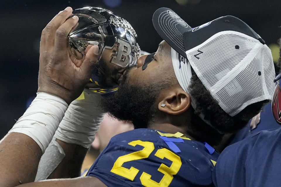 Michigan linebacker Michael Barrett kisses the trophy as he celebrates with teammates after defeating Purdue in the Big Ten championship NCAA college football game, early Sunday, Dec. 4, 2022, in Indianapolis. Michigan won, 43-22. (AP Photo/Darron Cummings)