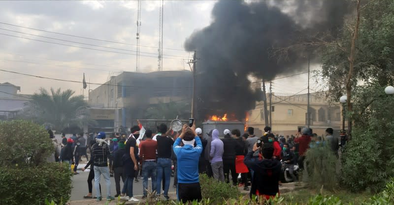 Smoke rises from the office of the shiite endowment after it was set on fire by protesters during ongoing anti-government protests in Nassiriya