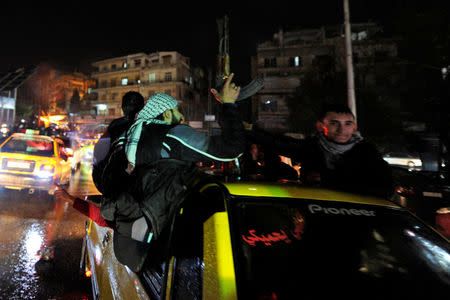 A man holds a weapon while touring with others the streets as they celebrate what they say is the Syrian army's victory against the rebels, in Aleppo, Syria December 12, 2016. REUTERS/Omar Sanadiki