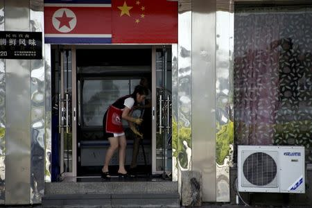 FILE PHOTO - A North Korean waitress cleans the floor of a North Korean restaurant in Dandong, Liaoning province, China, September 12, 2016. REUTERS/Thomas Peter/File Photo