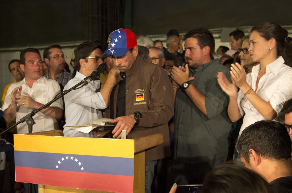 Venezuelan opposition leader Henrique Capriles, center, is surrounded by opposition leaders and supporters after he finished his speech in Caracas, Venezuela, Friday, April, 7, 2017. Capriles said today he was barred from seeking office for 15 years. The Governor of Miranda state, who came within a whisker of defeating President Nicolas Maduro in 2013 elections, is the latest in a number of prominent opposition politicians to be targeted by the embattled socialist leader's government. (AP Photo/Ariana Cubillos)