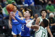 BYU guard Alex Barcello, left, shoots next to Oregon forward Quincy Guerrier during the second half of an NCAA college basketball game in Portland, Ore., Tuesday, Nov. 16, 2021. (AP Photo/Craig Mitchelldyer)
