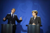 FILE - German Chancellor Angela Merkel, right, and Italian Prime Minister Matteo Renzi brief the media, after German and Italian government consultations at the chancellery in Berlin, March 17, 2014. Merkel has been credited with raising Germany’s profile and influence, helping hold a fractious European Union together, managing a string of crises and being a role model for women in a near-record tenure. Her designated successor, Olaf Scholz, is expected to take office Wednesday, Dec. 8, 2021. (AP Photo/Markus Schreiber File)