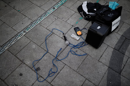 Microphone and speakers lie on the ground as Japanese Yuuka Hasumi, 17, and Ibuki Ito, 17, also from Japan, who want to become K-pop stars, perform during their street performance in Hongdae area of Seoul, South Korea, March 21, 2019. REUTERS/Kim Hong-Ji