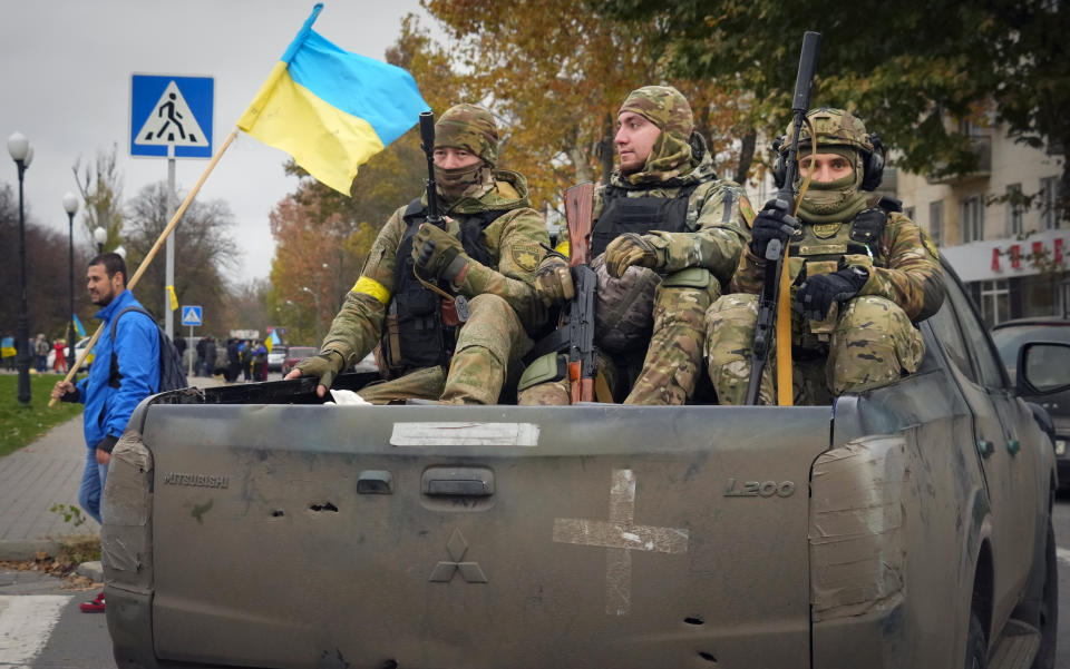 Ukrainian soldiers sit in a pickup in central Kherson, Ukraine, Sunday, Nov. 13, 2022. The Russian retreat from Kherson marked a triumphant milestone in Ukraine's pushback against Moscow's invasion almost nine months ago. (AP Photo/Efrem Lukatsky)