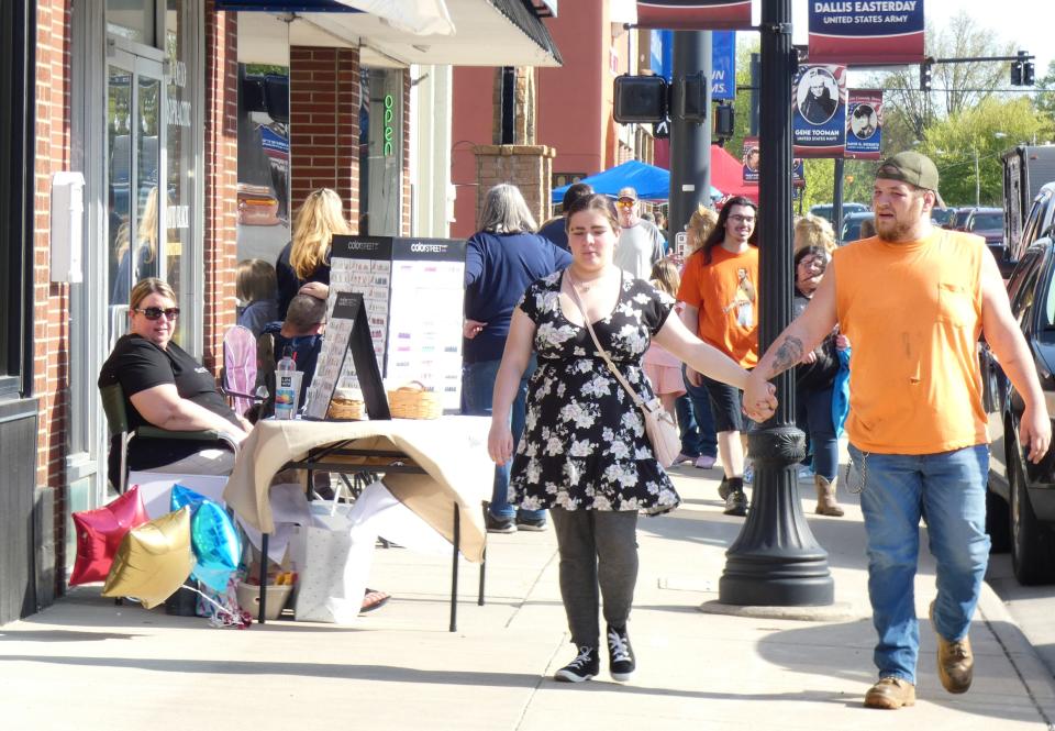 A couple strolls down South Sandusky Avenue during the Bucyrus Area Chamber of Commerce’s May First Friday in 2023. The music for Friday's opening event of 2024 will be played by Bound by Love.