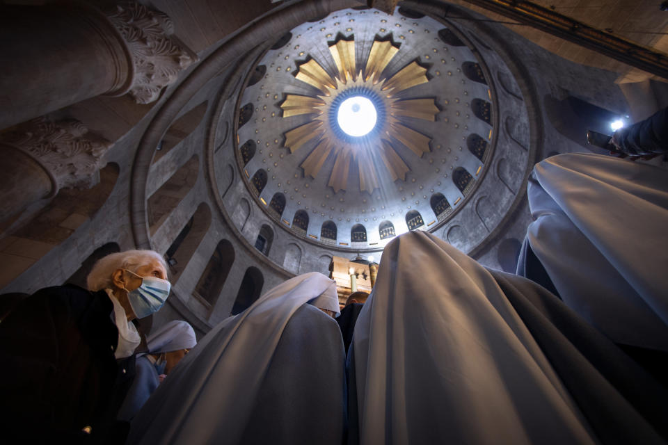 A woman wearing a face mask attends Easter Sunday Mass led by Latin Patriarch of Jerusalem Pierbattista Pizzaballa at the Church of the Holy Sepulchre, where many Christians believe Jesus was crucified, buried and rose from the dead, in the Old City of Jerusalem, Sunday, April 4, 2021. (AP Photo/Oded Balilty)
