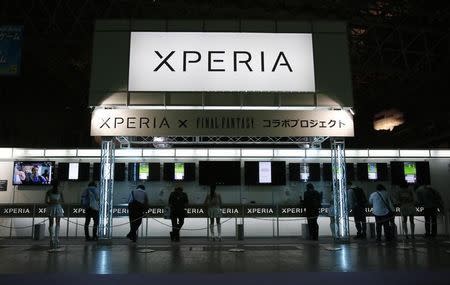 A signboard displaying the logo of Sony Corp's smartphone line Xperia is seen above its booth as visitors try out game applications on the devices during the Tokyo Game Show 2014 in Makuhari, east of Tokyo September 18, 2014. REUTERS/Yuya Shino