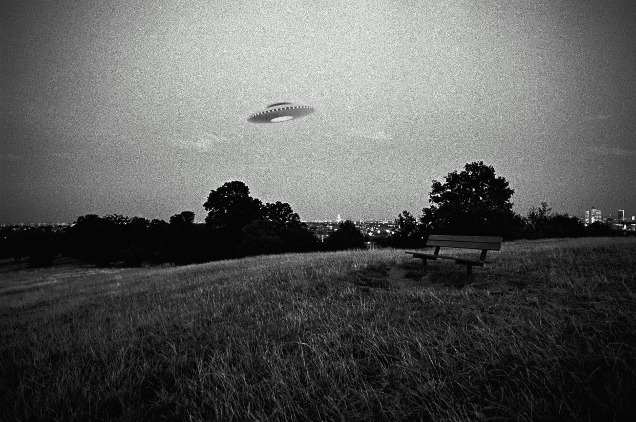 Do aliens exist? A UFO flies above a field in this digital composite. (Photo: Getty Images)