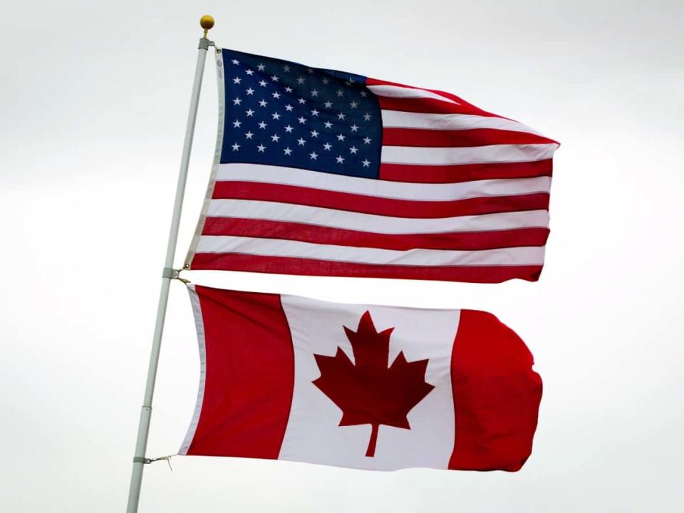 Canadian and American flags fly together in Point Roberts, Washington, U.S. a pene-exclave on the southernmost tip of the Tsawwassen peninsula, south of Vancouver. (Darryl Dyck/The Canadian Press - image credit)