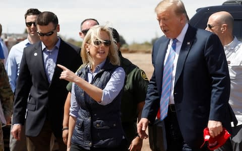 Nielsen walks with Trump during a visit to a section of the border wall in California - Credit: Reuters