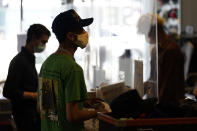 FILE - In this July 19 2021 file photo, employees check out customers at 2nd Street second hand store in the Fairfax district of Los Angeles. New evidence showing the delta variant is as contagious as chickenpox has prompted U.S. health officials to consider changing advice on how the nation fights the coronavirus. Recommending masks for everyone and requiring vaccines for doctors and other health care providers are among measures the Centers for Disease Control and Prevention is considering, Friday, July 30. (AP Photo/Marcio Jose Sanchez, File)