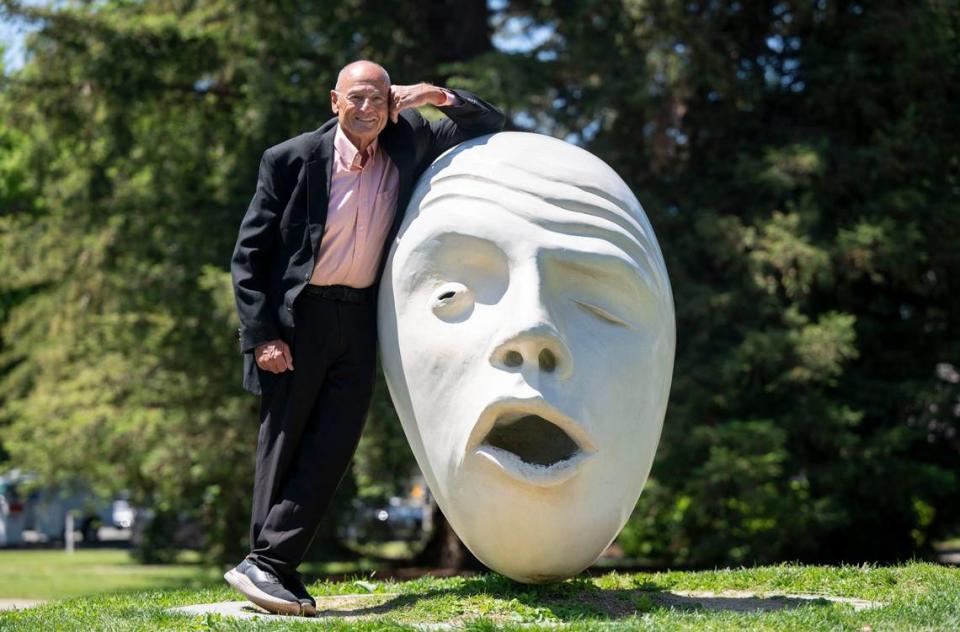 Bob Dunning, left, stands with an Egghead sculpture Tuesday at UC Davis, his alma mater. Dunning, who has been the local columnist for the Davis Enterprise for 54 years, is the latest victim of media downsizing.