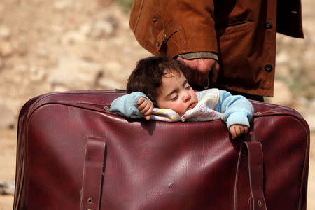 A child sleeps in a bag in the village of Beit Sawa, eastern Ghouta, Syria March 15, 2018. REUTERS/Omar Sanadiki