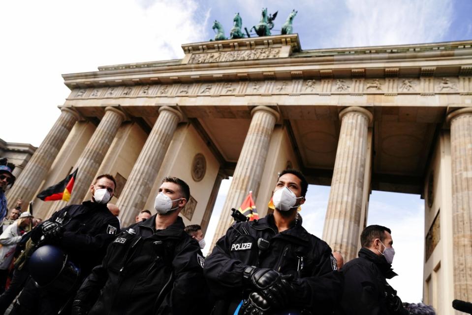 Polizisten mit Mundschutz stehen vor einer Demonstration gegen die Corona-Maßnahmen vor dem Brandenburger Tor.<span class="copyright">Kay Nietfeld / dpa</span>