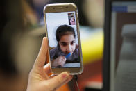 Schoolgirl Leyle listens to social worker Gina Figge of Christian charity the Arche, or Ark, during an online homework lesson in the Hellersdorf suburb of Berlin, Germany, Thursday, April 2, 2020. Staff are trying to provide one-to-one tutoring to older children using video chatting apps, to ensure they don’t fall too far behind on their school work. (AP Photo/Markus Schreiber)