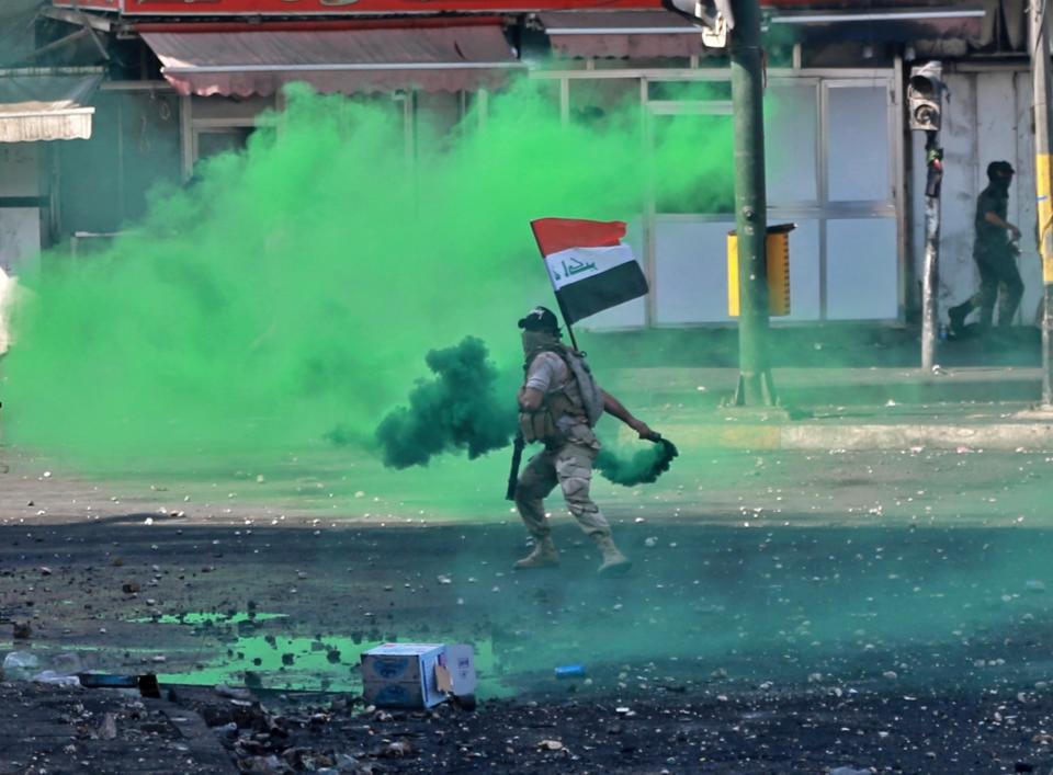 Security forces fire tear gas and smoke bombs during clashes between Iraqi security forces and anti-government protesters in Baghdad, Iraq, Monday, Nov. 11, 2019. (AP Photo/Khalid Mohammed)