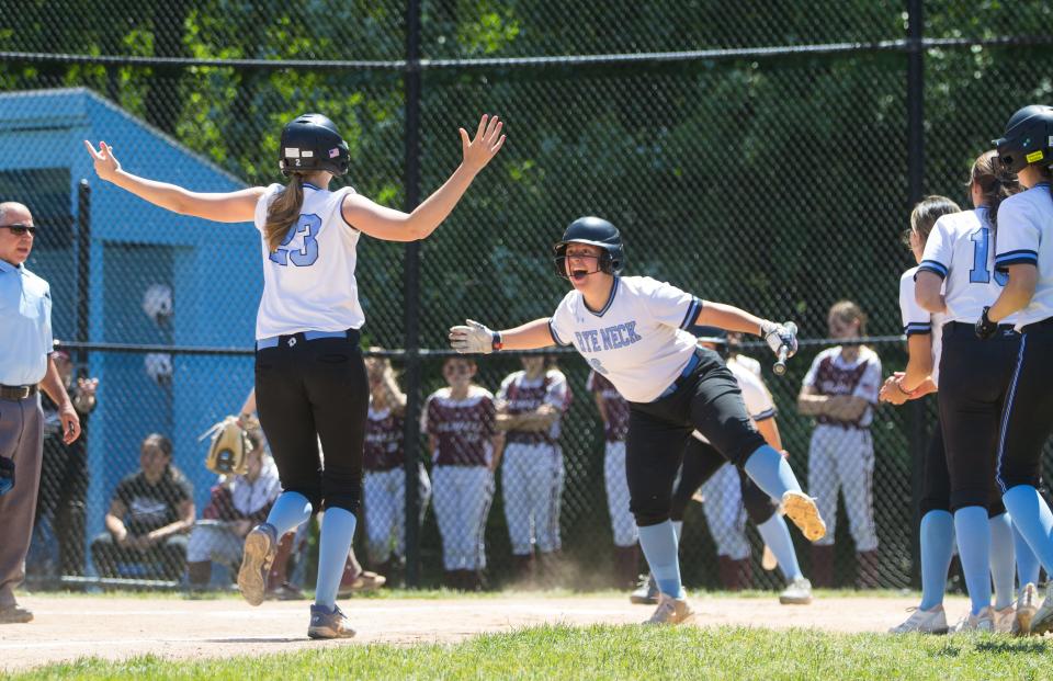 Rye Neck's Clare Picone (26) greets Katie Blanch (23) at home plate after her go-ahead home run against Valhalla in the Section 1 Class B semifinals on May 27, 2023.
