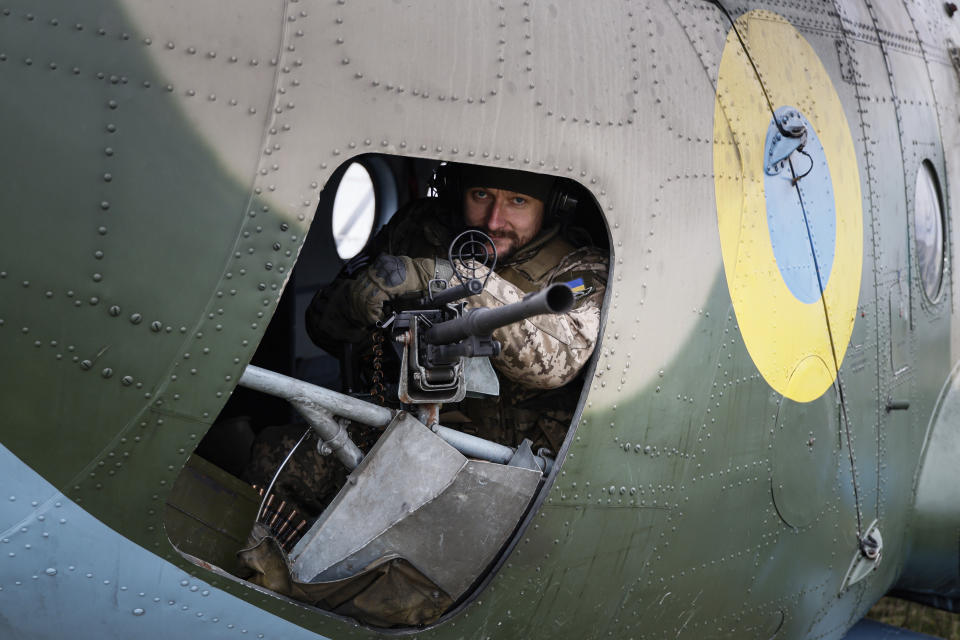 A Ukrainian serviceman of 12 aviation brigade sits inside an Mi-8 combat helicopter before flight during a combat mission in Kharkiv region, Ukraine, Sunday, April 2, 2023. (AP Photo/Alex Babenko)