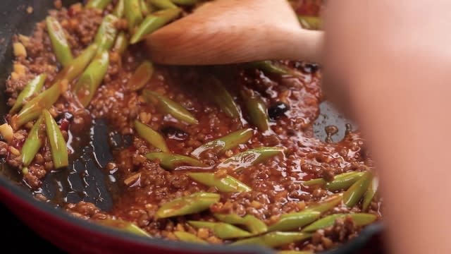 Stir frying spicy bean paste gravy with woodlen spatula