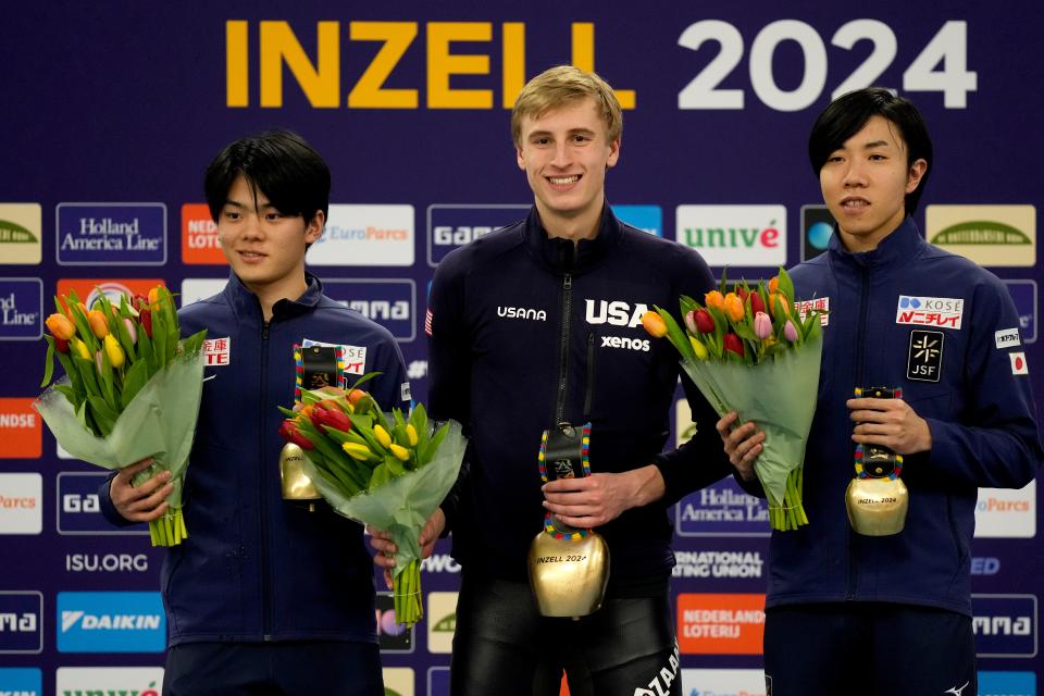 Jordan Stolz of the United States, center, Shomu Sasaki of Japan, left, and Riku Tsuchiya of Japan celebrate on the podium after the men's 500 meters