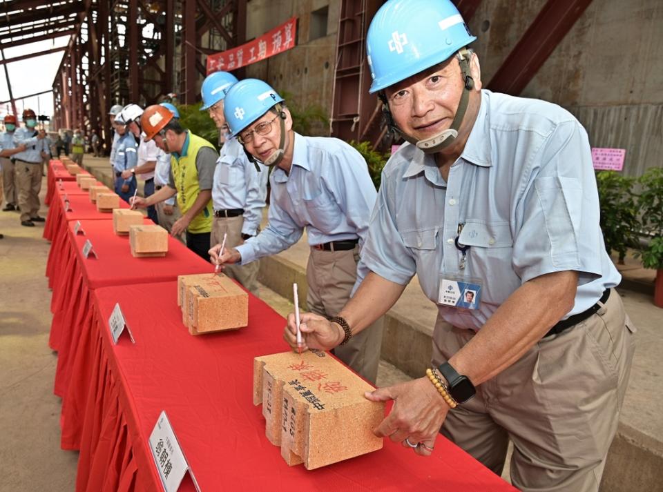 中鋼董事長翁朝棟（右）於築爐砌磚上簽名。中鋼提供