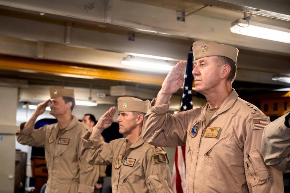 Rear Adm. Kavon Hakimzadeh, the oncoming commander of the Ike Carrier Strike Group; Rear Adm. Marc Miguez, off-going commander; and Vice Adm. George Wikoff, commander of US Naval Forces Central Command, US 5th Fleet, salute during a change of command ceremony USS Dwight D. Eisenhower in the Red Sea.