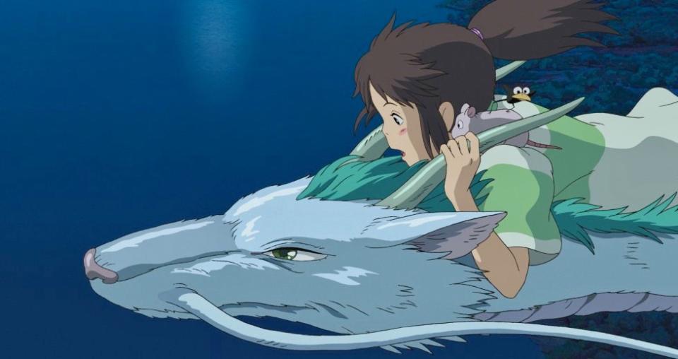 Chihiro rides on Haku's back as he flies them home. (Studio Ghibli)