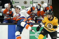 New York Islanders center Casey Cizikas, left, falls into the boards after contact with Boston Bruins right wing David Pastrnak, right, in the second period of an NHL hockey game, Thursday, April 15, 2021, in Boston. (AP Photo/Elise Amendola)