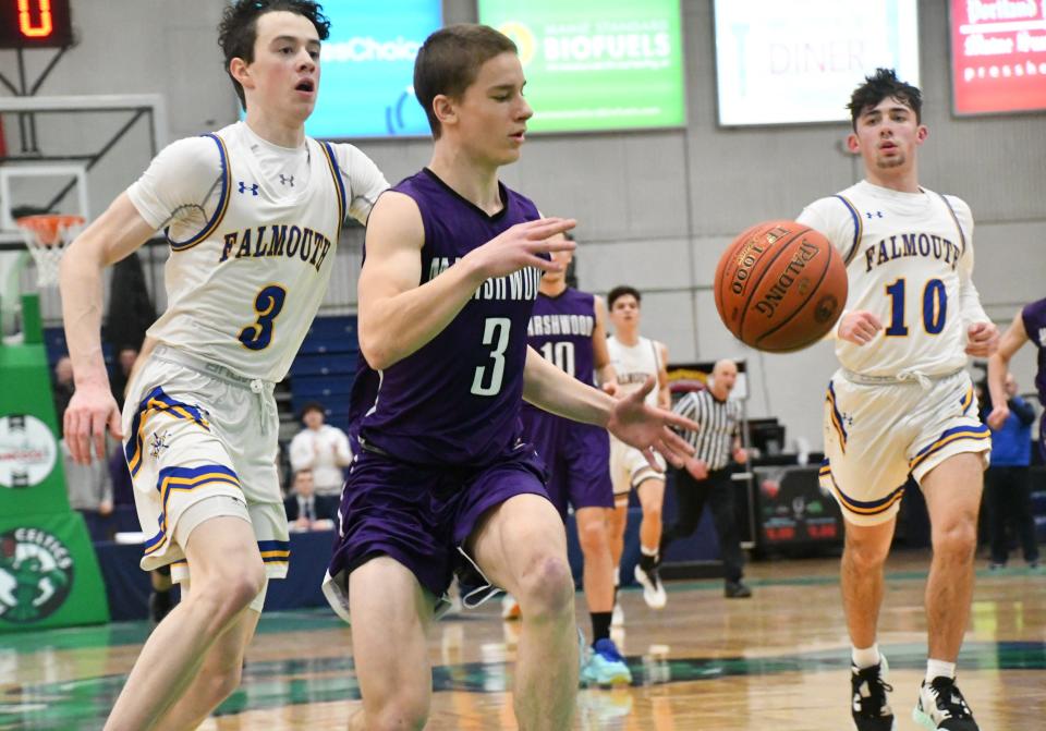 Marshwood’s David Lane, center, eyes the ball as he is chased by Falmouth’s Judd Armstrong (3) and Peyton Mitchell (10) during the Class A South championship game Friday night at the Portland Expo. Marshwood lost in the regional final for the second year in a row, 40-31