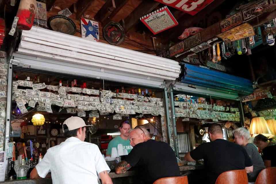 Signed dollar bills and an eclectic collection of memorabilia decorate the bar at Huc-A-Poo's.