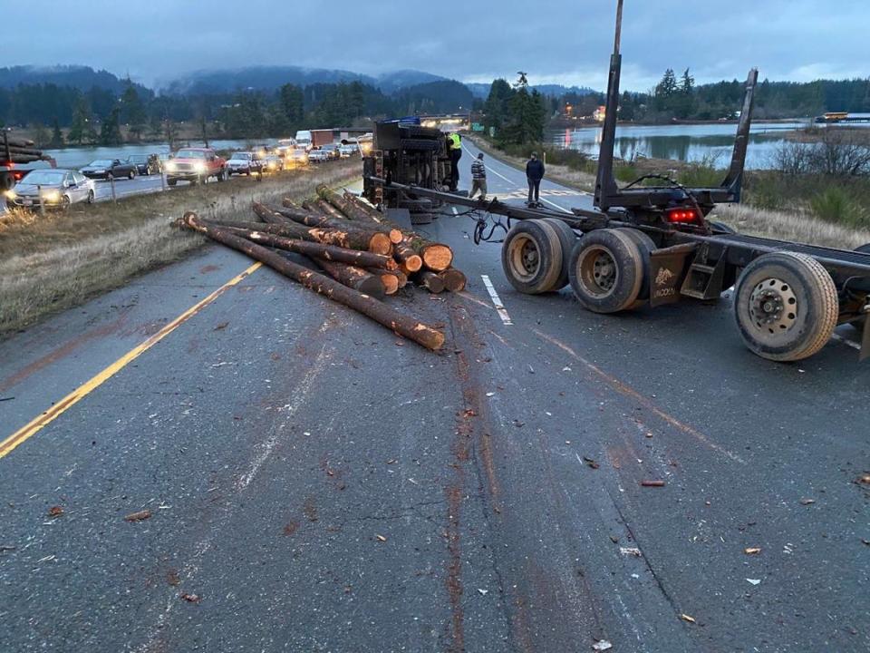 A four-vehicle collision on Highway 101 Friday morning in Olympia injured two people and fully blocked the highway after a log truck spilled its load.
