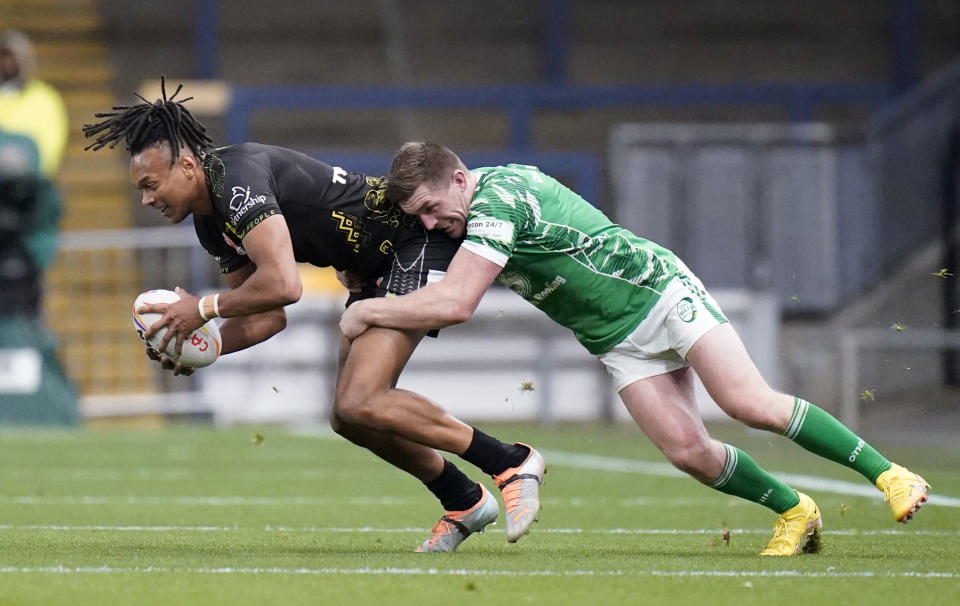 Jamaica's Alex Young is tackled by Ireland's Ed Chamberlain during the Rugby League World Cup group C match between Ireland and Jamaica at Headingley Stadium, Leeds, England, Sunday Oct. 16, 2022. (Danny Lawson/PA via AP)