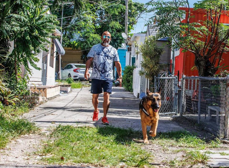 Richard Otero plays with his dog named Dumbbells in front of his home at the Gables Trailer Park, which has approximately 90 trailers and is located across from Graceland Memorial Park North on SW 44th Avenue. Residents are worried about being displaced as the city of Coral Gables is moving forward with the annexation process, on Wednesday, October 18, 2023.