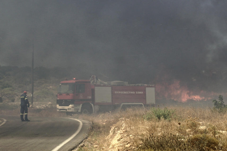 Firefighters extinguish a forest fire at Elafonisos island, south of Peloponnese peninsula, on Saturday, Aug. 10, 2019. A wildfire which broke out on Elafonisos island in southern Greece on Saturday has prompted the evacuation of a hotel and camping as a precautionary measure, with no injuries reported, according to Greek national news agency AMNA. (AP Photo/Nikolia Apostolou)