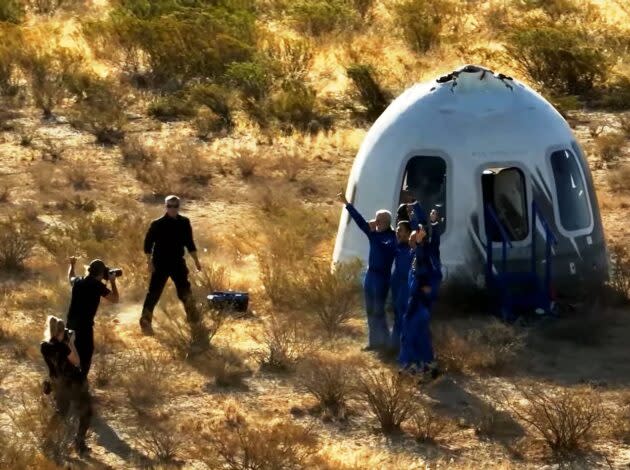 New Shepard’s crew members pose for a picture in front of their capsule. (Blue Origin via YouTube)