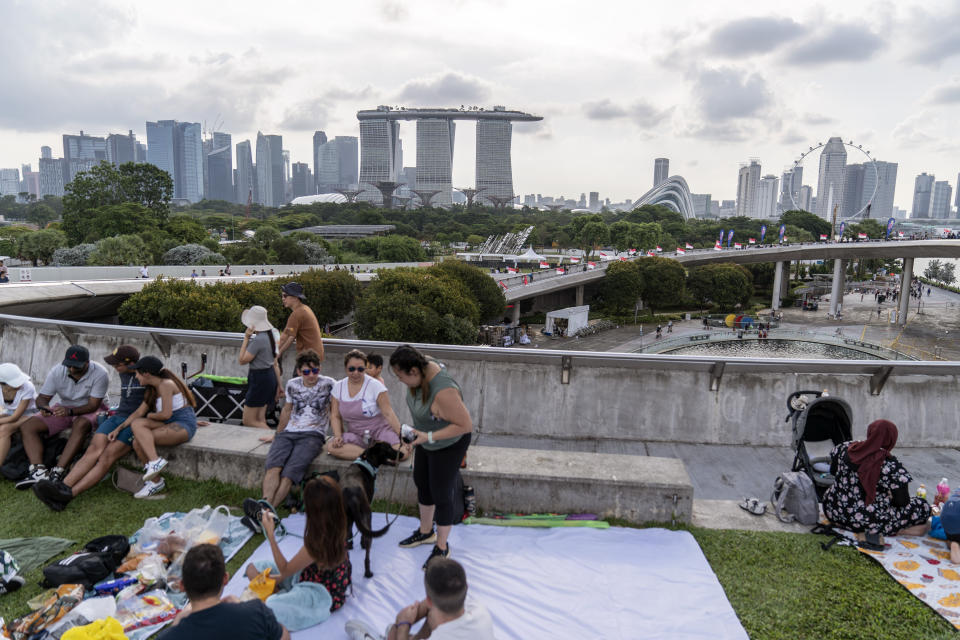 People picnic on the grassy roof of the Marina Barrage pumping station with a view of the Singapore skyline, Saturday, July 22, 2023. The barrage and the adjacent dam separates seawater to create a freshwater reservoir downtown, the city-state's largest and most urbanized catchment area. (AP Photo/David Goldman)